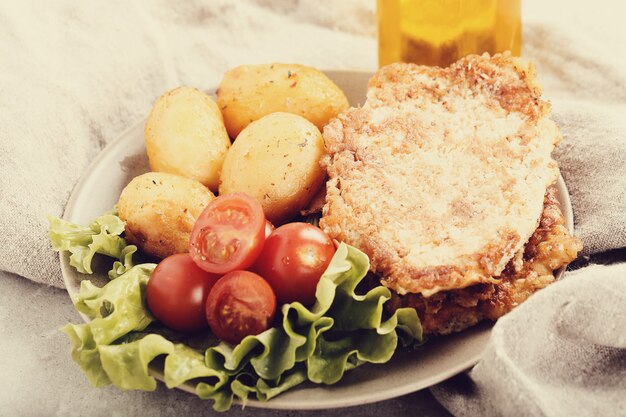 Deliciosa cena con filetes, papas hervidas y ensalada.