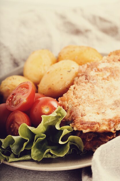 Deliciosa cena con filetes, papas hervidas y ensalada.