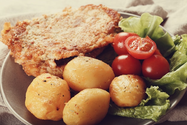 Deliciosa cena con filetes, papas hervidas y ensalada.