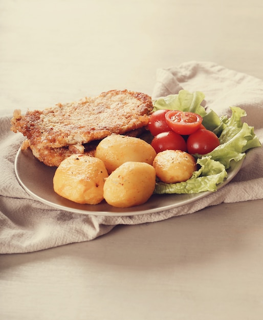 Deliciosa cena con filetes, papas hervidas y ensalada.