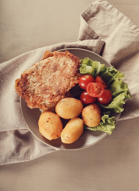 Deliciosa cena con filetes, papas hervidas y ensalada.