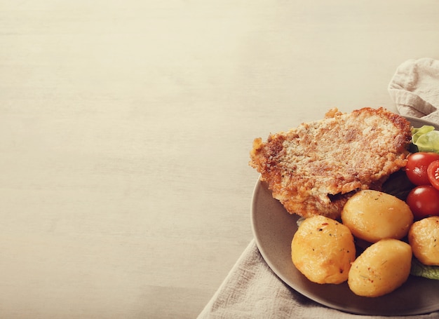 Deliciosa cena con filetes, papas hervidas y ensalada.