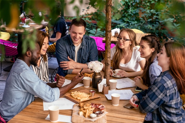 Deliciosa comida en la mesa de una reunión amistosa de mejores amigos en el acogedor restaurante al aire libre