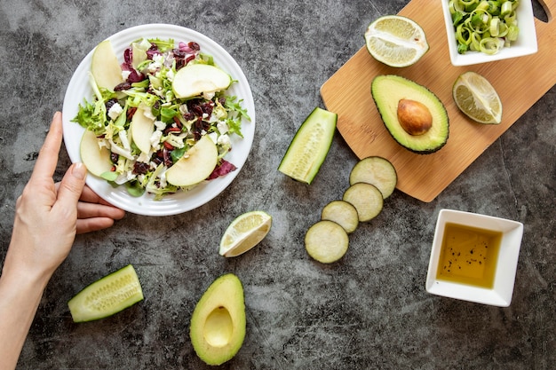 Deliciosa ensalada con aguacate sobre tabla de madera