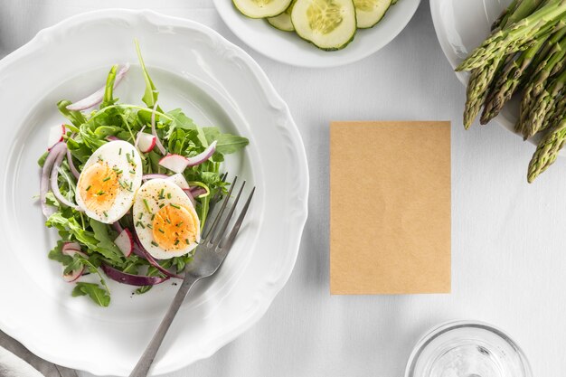 Deliciosa ensalada en un plato blanco con tarjeta vacía