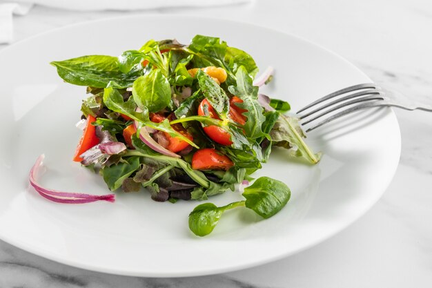 Deliciosa ensalada saludable en un arreglo de plato blanco