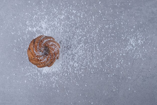 Deliciosa galleta sobre un montón de vainilla en polvo sobre la superficie de mármol