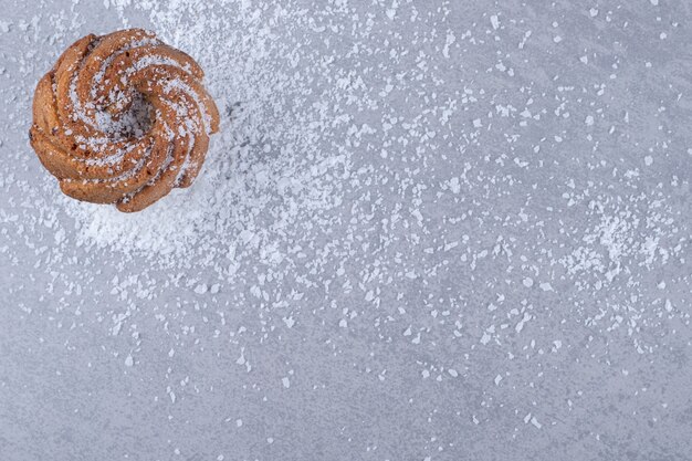 Deliciosa galleta sobre un montón de vainilla en polvo sobre la superficie de mármol