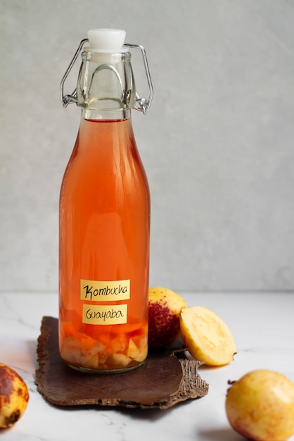 Foto gratuita deliciosa guayaba kombucha botella bodegón