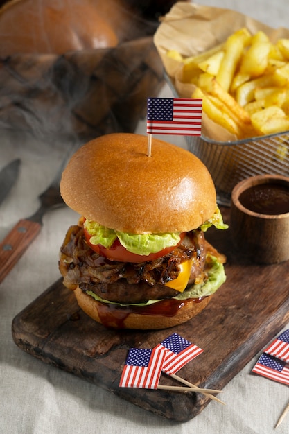 Foto gratuita deliciosa hamburguesa de alto ángulo con bandera de estados unidos y papas fritas