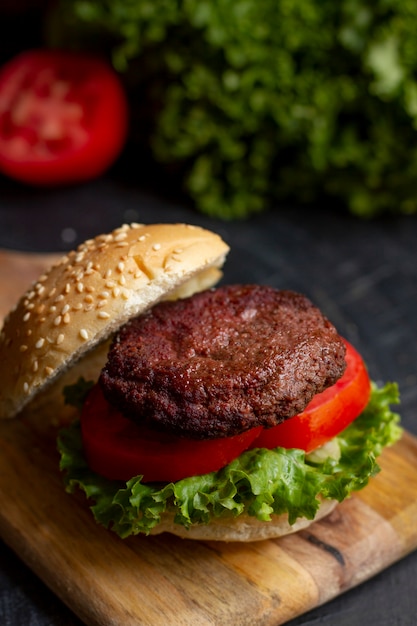 Foto gratuita deliciosa hamburguesa de alto ángulo sobre tabla de madera