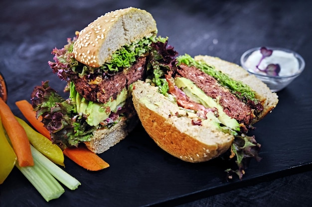 Deliciosa hamburguesa, papas fritas con ensalada en una mesa.