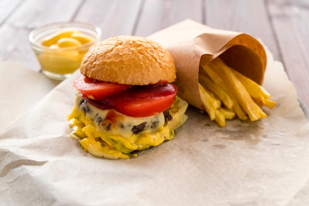 Foto gratuita deliciosa hamburguesa con queso con papas fritas