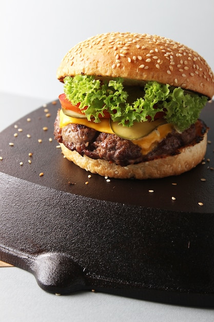 Deliciosa hamburguesa sobre una superficie negra aislada sobre una superficie blanca