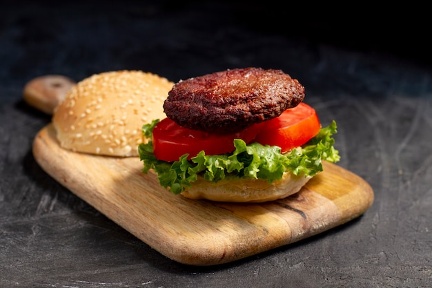 Foto gratuita deliciosa hamburguesa en tablero de madera