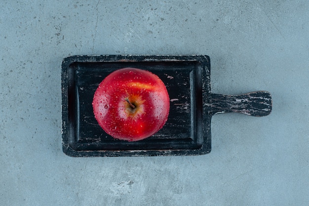 Foto gratuita deliciosa manzana roja en un tablero, sobre el fondo de mármol. foto de alta calidad