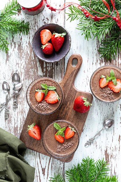 Deliciosa mousse de chocolate casera o panna cotta con bayas sobre una piedra blanca o fondo de madera Postre festivo Vertical