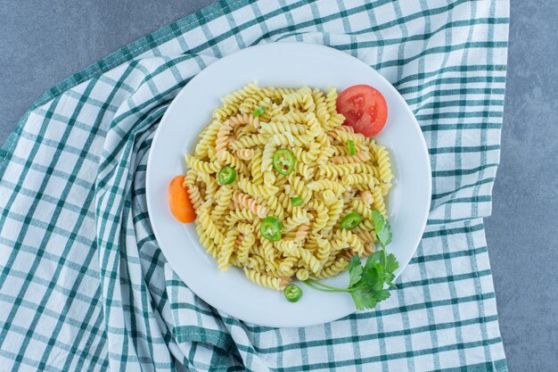 Deliciosa pasta fusilli con verduras en un plato blanco.