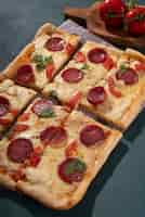 Foto gratuita deliciosa pizza cuadrada de alto ángulo con pepperoni