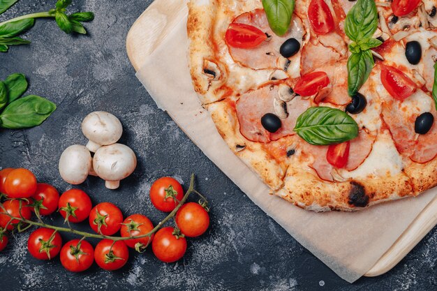 Deliciosa pizza napolitana a bordo con tomates cherry, espacio libre para texto