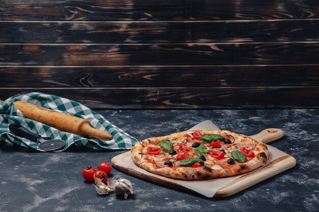 Deliciosa pizza napolitana a bordo con tomates cherry, espacio libre para texto