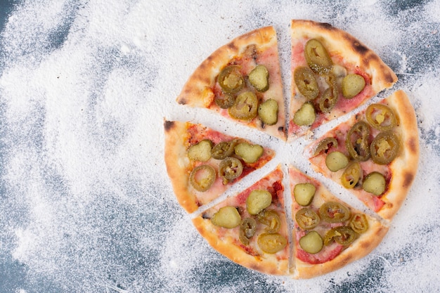 Deliciosa pizza de salami con jalapeños sobre mármol.