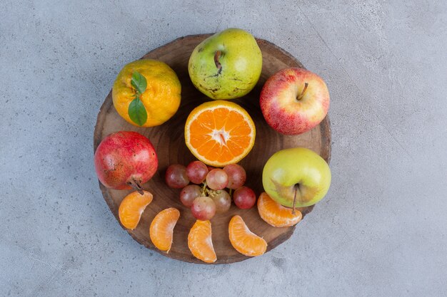 Una deliciosa porción de frutas sobre una tabla de madera sobre fondo de mármol.