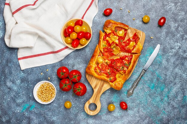 Deliciosa tarta abierta rústica casera, galette con varios tomates y piñones