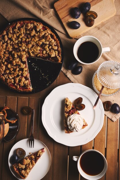 Deliciosa tarta de ciruela con café Chemex e ingredientes con tela sobre una mesa de madera con tela