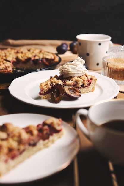 Deliciosa tarta de ciruela con café Chemex e ingredientes con tela sobre una mesa de madera con tela