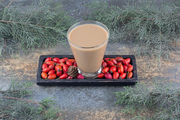 Una deliciosa taza de café con rosa mosqueta en tablero oscuro. Foto de alta calidad