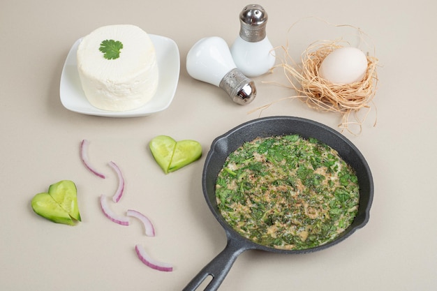 Deliciosa tortilla con verduras en sartén oscura.