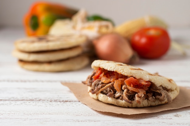 Foto gratuita deliciosas arepas con carne y tomates