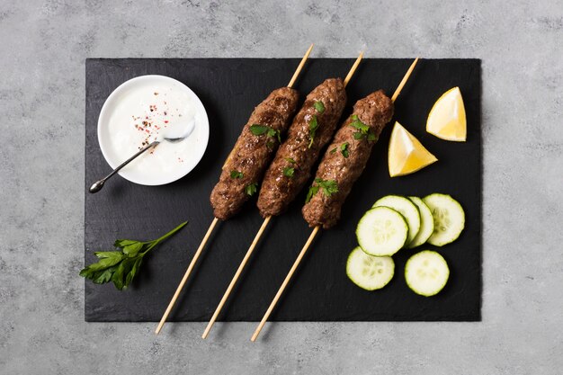 Deliciosas brochetas de comida rápida árabe y rodajas de pepino