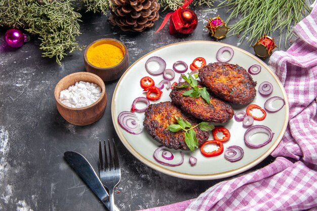 Deliciosas chuletas de vista frontal con aros de cebolla