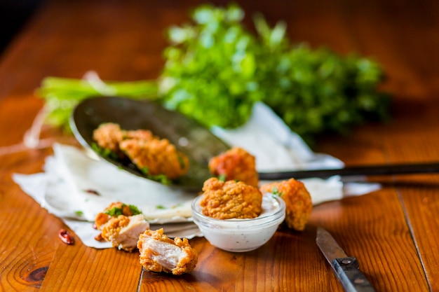 Deliciosas croquetas de pollo crujiente con salsa de ajo en la mesa de madera
