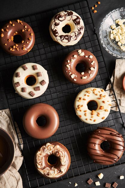 deliciosas donas cubiertas con el glaseado de chocolate con los ingredientes en una mesa