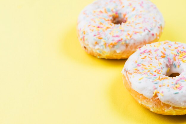 Deliciosas donas con glaseado sobre fondo amarillo