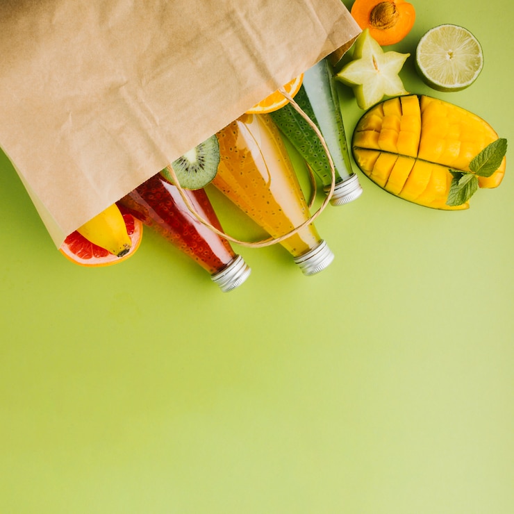 Foto gratuito deliciosas frutas y jugos en bolsa de papel copyspace.
