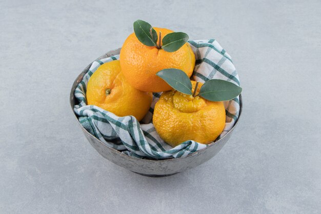 Deliciosas frutas mandarina en recipiente de metal