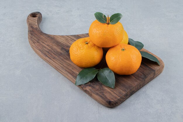 Deliciosas frutas mandarina en tablero de madera