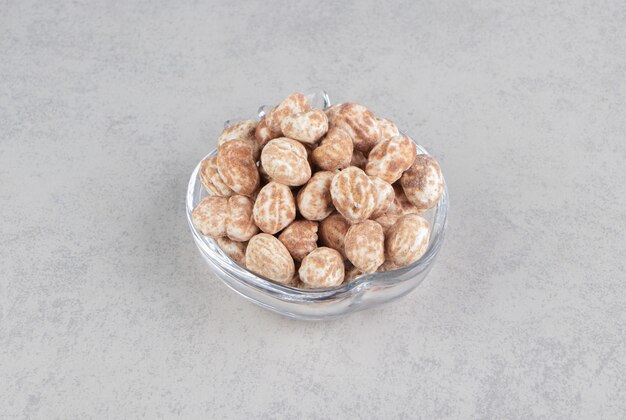 Deliciosas galletas de canela en el recipiente sobre la superficie de mármol