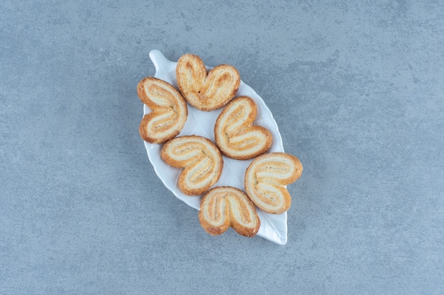 Foto gratuita deliciosas galletas caseras en plato blanco sobre mesa gris.