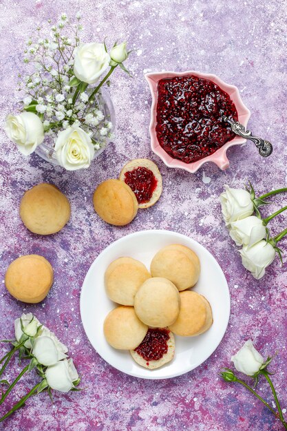 Deliciosas galletas caseras que sirven con mermelada de frambuesa, vista superior