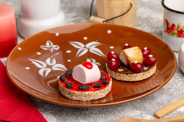 Deliciosas galletas con cornejos dentro de la placa marrón sobre gris