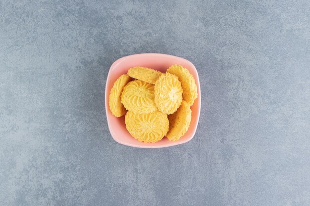 Deliciosas galletas dulces en tazón de fuente rosa.