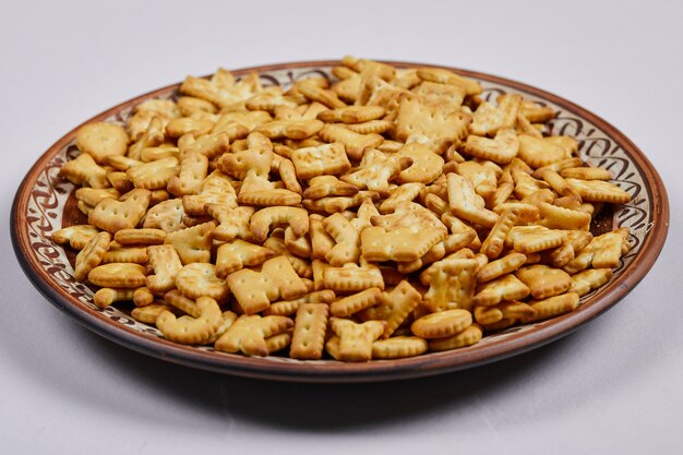 Deliciosas galletas de letras en un plato de cerámica.