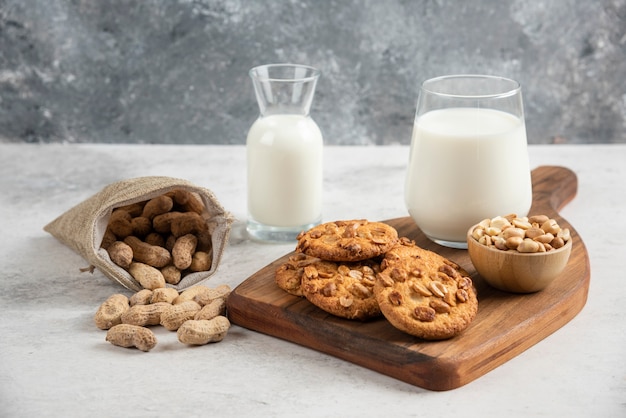 Deliciosas galletas con miel, leche y maní sobre tabla de madera.