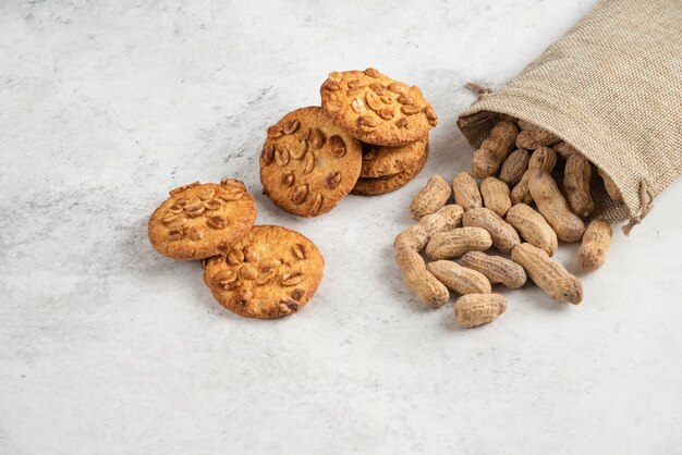 Deliciosas galletas con miel orgánica y maní en mesa de mármol.