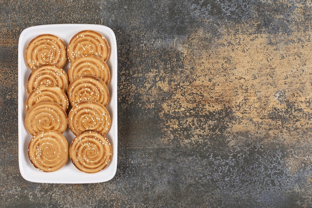 Foto gratuita deliciosas galletas con semillas de sésamo en un plato blanco.